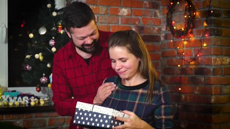 Schöner-junger-bärtiger-Mann-gibt-seine-Freundin-ein-Neujahrs-Geschenk-box