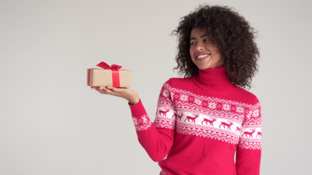 African-american-woman-pointing-at-Christmas-gift-box