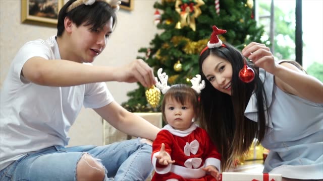 Glückliche-Familie-Mutter-Vater-und-Kind-Tochter-mit-Weihnachtsbaum-zu-Hause.-Closeup-Zeitlupe-Porträt-des-liebenden-Familie,-Frohe-Weihnachten-und-schöne-Feiertage!
