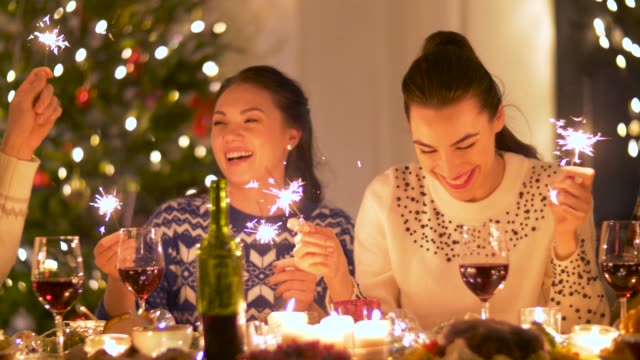 Glückliche-Freunde-mit-Wunderkerzen,-die-Weihnachts-Dinner-zu-Hause