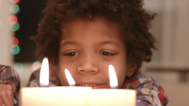 Smiling-boy-looks-at-candle.