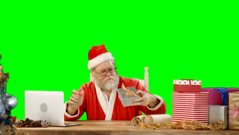 Santa-Claus-mit-Laptop-während-der-Überprüfung-Geschenkbox
