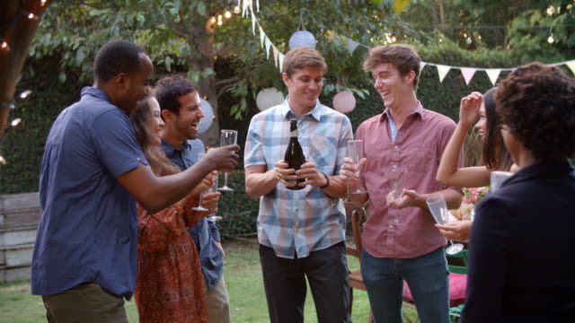 Friends-Celebrating-With-Champagne-At-Outdoor-Backyard-Party