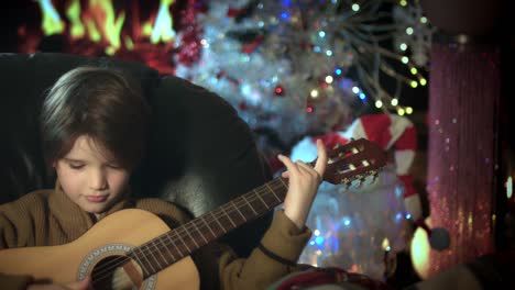 4-k-Weihnachten-und-Neujahr-Urlaub-Kind-Gitarre-am-Kamin