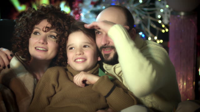 4-k-Weihnachten-und-Neujahr-Urlaub-Familie-am-Kamin-schauen-glücklich