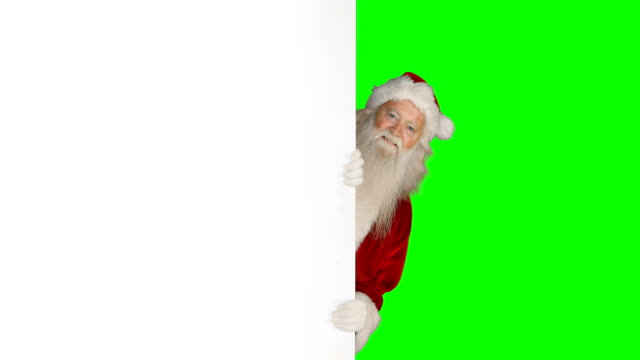 Überrascht-Weihnachtsmann-versteckt-sich-hinter-weißen-Bildschirm