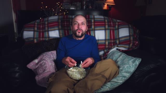 4k-Authentic-Shot-of-a-Funny-Man-Watching-Comedy-Movie-with-Popcorn