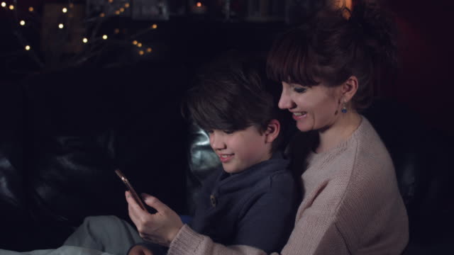 4k-authentische-Aufnahme-eines-Kindes-mit-seiner-Mutter-auf-der-Suche-im-Telefon--und-Lächeln