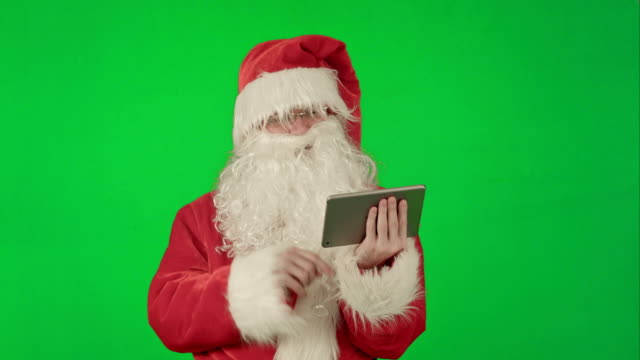 Fröhlicher-Weihnachtsmann-ist-eine-Tablette-in-den-Händen-auf-einem-Green-Screen-Chrom-Schlüssel-hält.
