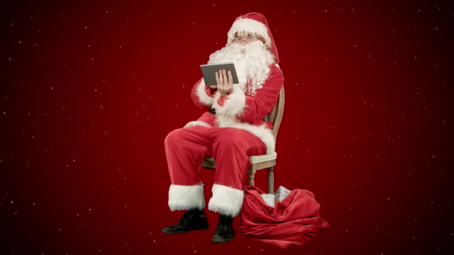 Santa-Claus-mit-Tablet-PC,-Internet-surfen-und-kommunizieren-in-sozialen-Medien-mit-Kindern-auf-rotem-Grund-mit-Schnee