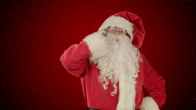 Der-Weihnachtsmann-spricht-auf-seinem-Handy-mit-einem-überraschten-Blick-ins-Gesicht.-Auf-rotem-Hintergrund-mit-Schnee