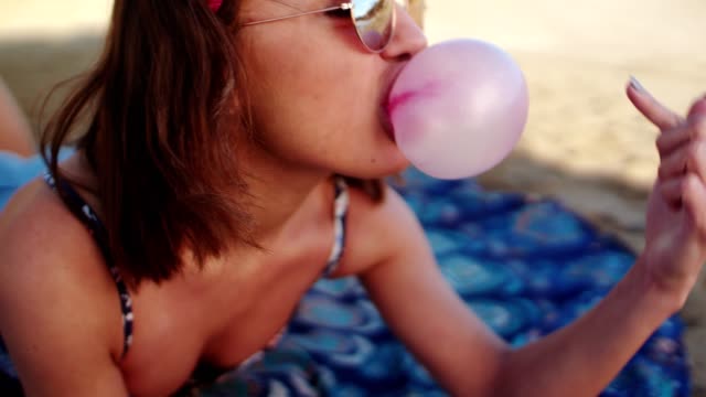Frau-popping-eine-Blase-am-Strand