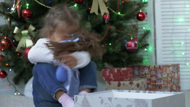 Nahaufnahme-der-niedliche-kleine-Mädchen-Weihnachtsgeschenk-zu-öffnen.