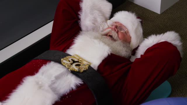 Santa-Claus-tratando-de-hacer-un-sentar-para-arriba-en-gimnasio