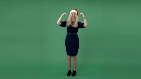 Young-blonde-woman-in-a-santa's-cap-showing-thumbs-up-and-smiling,-chroma-key-green-screen