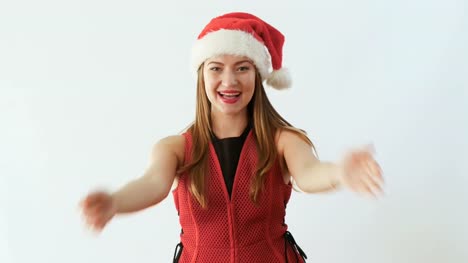 Junges-Mädchen-in-die-Weihnachtsmütze-sendet-ein-Luft-Kuss-und-lächelnd-auf-weißem-Hintergrund