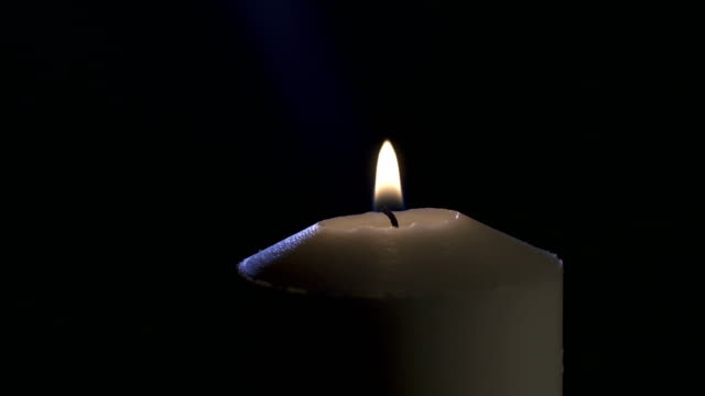 Slow-motion-macro-footage-of-a-white-candle-on-a-dark-background
