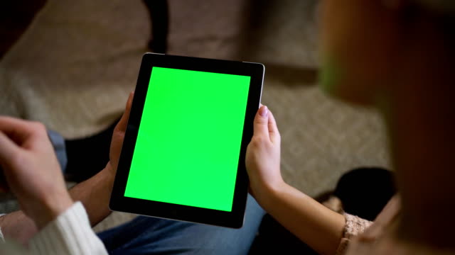 Couple-look-at-green-screen-ipad-on-christmas-eve