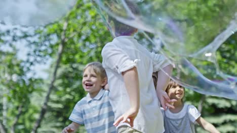 Niños-entusiasmados-captura-de-burbujas-en-el-Parque
