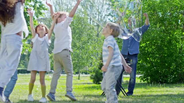 Mann,-riesige-Seifenblasen-für-Kinder-im-Park