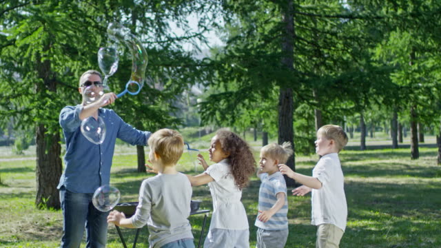 Man-Performing-Tricks-with-Soap-Bubbles-for-Children