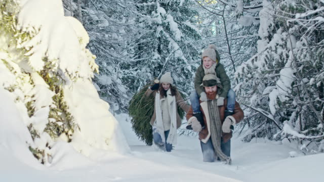 Familia-caminar-a-través-de-nieve-profunda-en-bosque