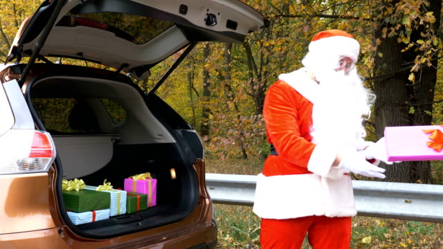 Der-Weihnachtsmann-bringt-Geschenke-in-den-Kofferraum-eines-Autos-50-fps