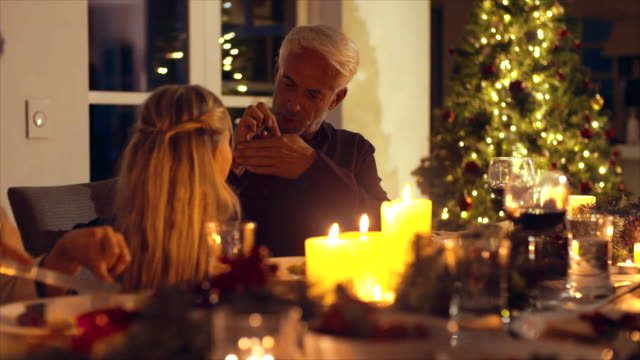 Grandfather-and-granddaughter-playing-at-Christmas-dinner-table
