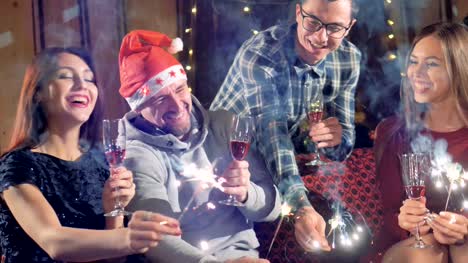 Happy-cheerful-group-of-friends-at-new-year-christmas-party-lighting-sparklers-having-fun-smiling-celebrating-new-year's-eve.-4K.