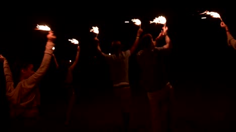 Amigos-de-joven-inconformista-multiétnica-celebrando-en-fiesta-al-aire-libre-con-luces-de-Bengala