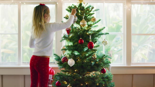 Junges-Mädchen-dekorieren-Weihnachtsbaum
