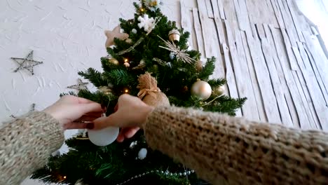 Woman-decorating-christmas-tree-with-toys