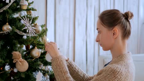 Woman-decorating-christmas-tree-with-toys