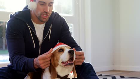 4K-4k-Hund-lächelnd-jungen-Mann-sein-Haustier-Santa-Mütze-aufsetzen