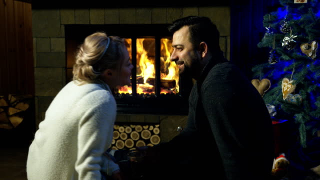 Loving-couple-at-fireplace-before-Christmas