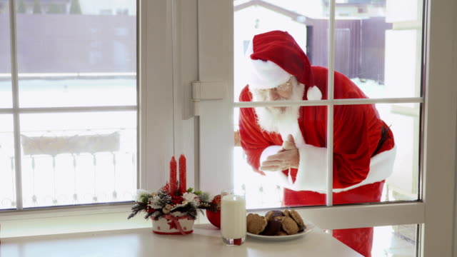 Santa-Claus-klopfen-in-Fenster-und-wollen,-dass-Milch-und-Kekse-schmecken