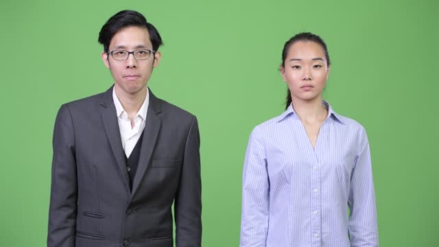 Junge-asiatische-Geschäft-Paar-zusammen-in-die-Kamera-zeigen