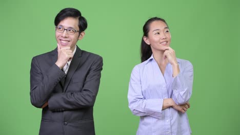 Young-happy-Asian-business-couple-thinking-together