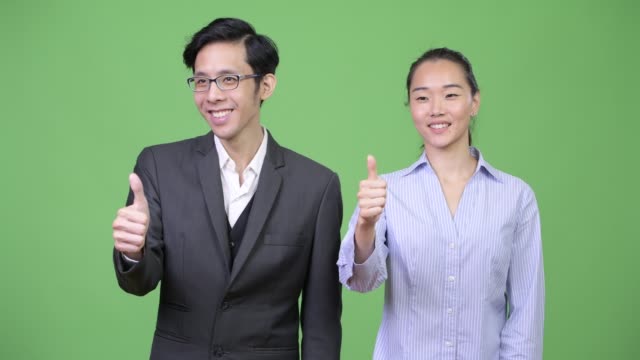 Junge-asiatische-Geschäft-paar-Daumen-zusammen-aufgeben