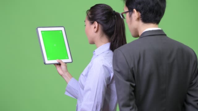 Junge-asiatische-Geschäft-paar-digital-Tablette-zusammen-mit