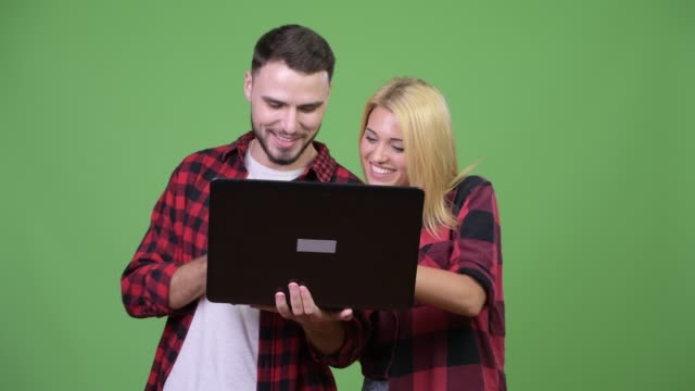 Junge-glückliche-Paar-Lächeln-während-mit-Laptop-zusammen