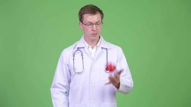 Porträt-des-jungen-Mann-Arzt-spielen-mit-roter-Apfel