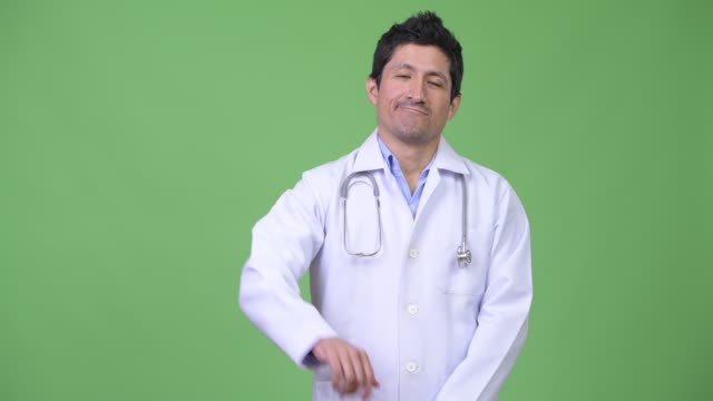Ernsthafte-Hispanic-Mann-Arzt-geben-Daumen-nach-unten