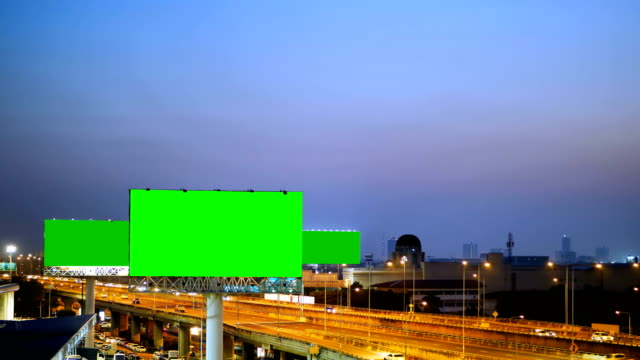 Green-screen-of-advertising-billboard-on-expressway-during-the-twilight-with-city-background-in-Bangkok,-Thailand.