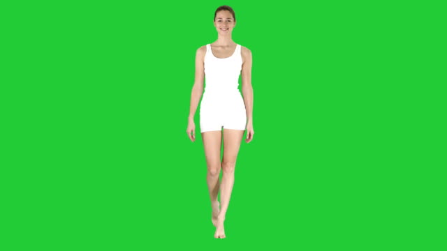 Dame-im-weißen-Sport-Dessous-spazieren-und-lächelnd-auf-einem-Green-Screen,-Chroma-Key