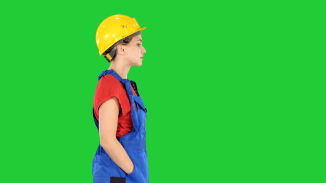 Construction-worker-lady-walking-emotionless-on-a-Green-Screen,-Chroma-Key