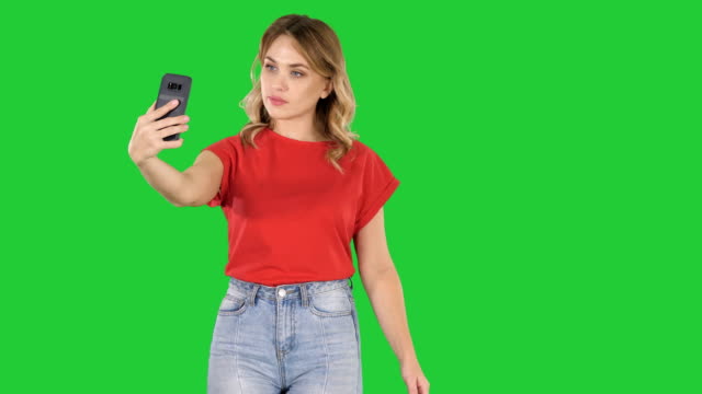 Linda-chica-haciendo-selfie-caminando-sobre-una-pantalla-verde-Chroma-Key