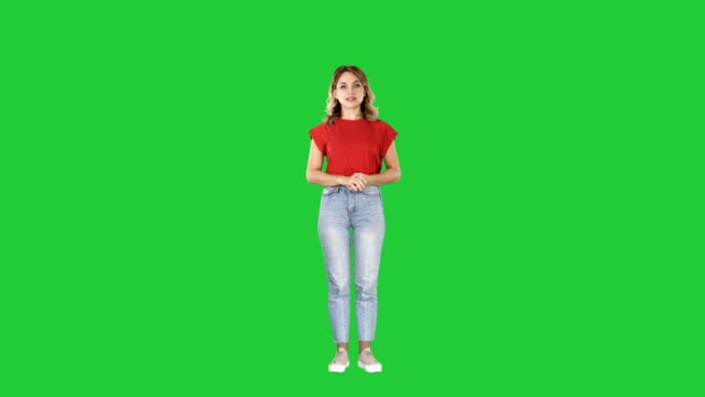 Young-beautiful-cute-cheerful-woman-standing-and-looking-at-camera-waiting-for-something-on-a-Green-Screen,-Chroma-Key