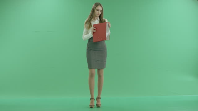 Negocio-mujer-mirando-carpetas-con-documentos-sobre-pantalla-verde