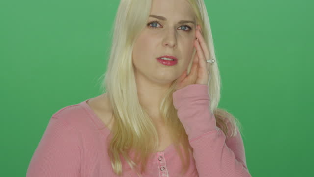 Beautiful-blonde-woman-with-wedding-ring-looking-sad-and-upset,-on-a-green-screen-studio-background